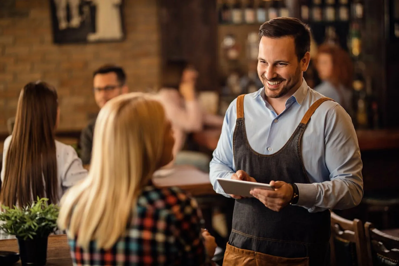 Restauranthouder in gesprek met gasten aan tafel